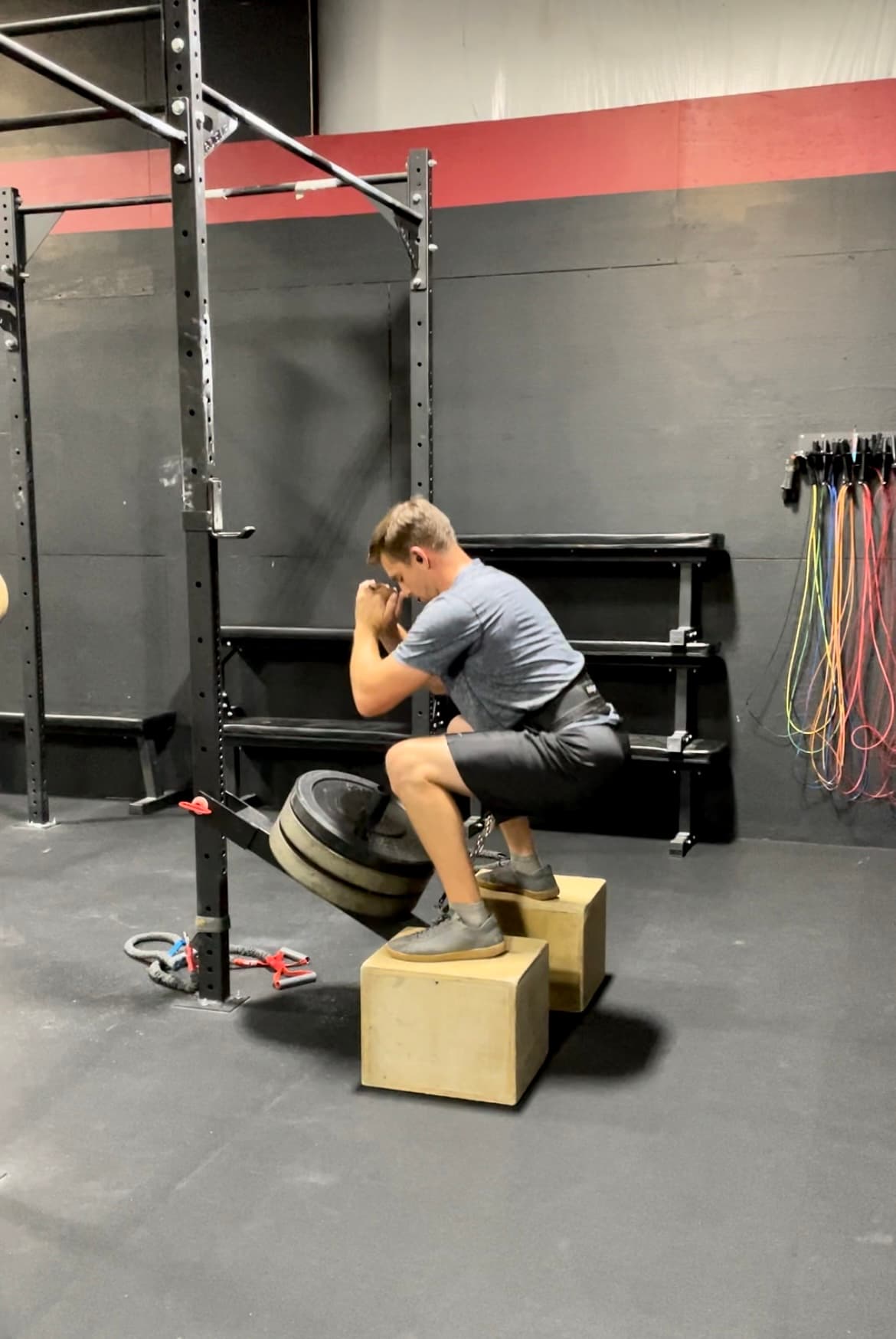 A member performs a kettlebell swing with proper form during a class.